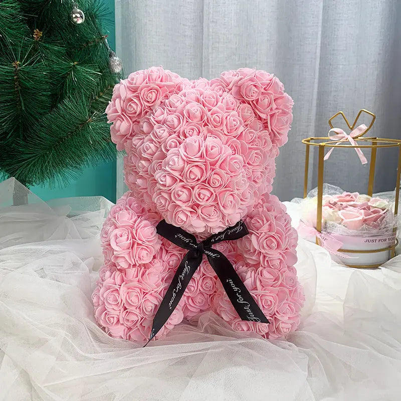 a pink pink teddy bear sitting on a bed 