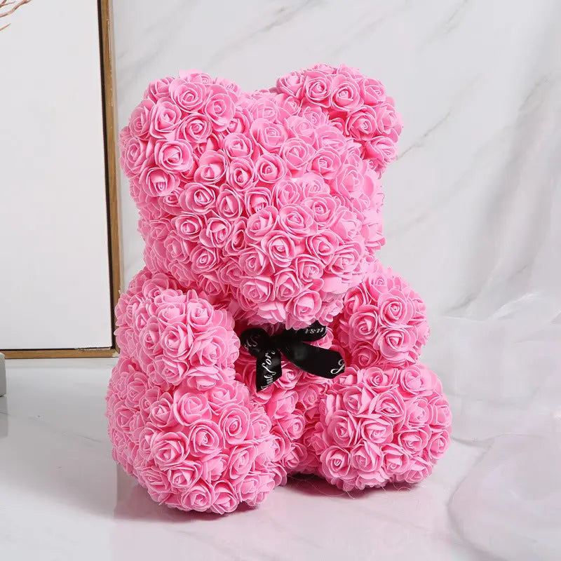 a pink pink teddy bear sitting on top of a white table 