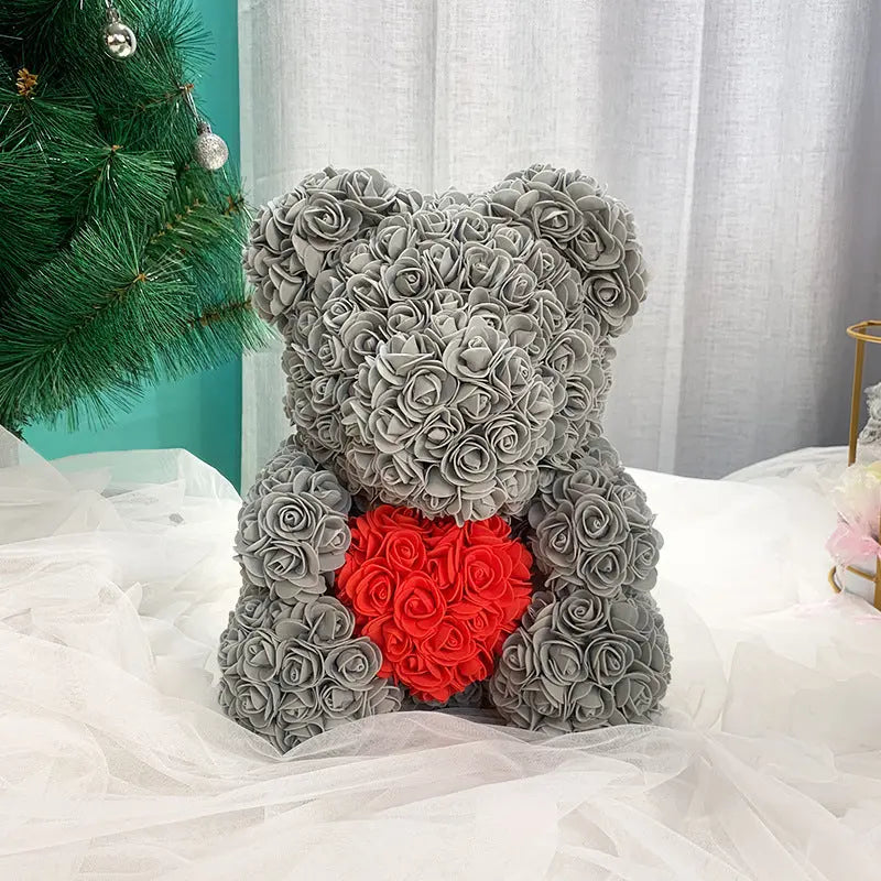 a teddy bear with a red bow sitting on a bed 